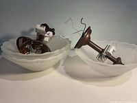 Two uninstalled fixtures showing bronze stems, wiring, sockets and separate frosted glass shades