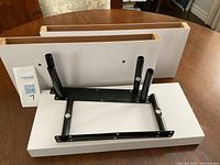 Three white floating shelves with black mounting brackets shown on tabletop