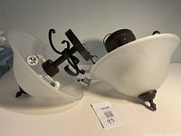 Two frosted glass bowl ceiling fixtures with black metal hardware shown side by side