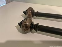 Close-up of brown stone finials on black rods