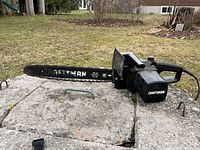 Overall view of Craftsman electric chainsaw on outdoor surface