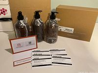 Three amber pump bottles wrapped, labels and instruction card displayed beside shipping box