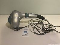 Side view of ObusForme corded massager showing handle, cord, and overall shape