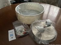 Drum shade, mounting base, hardware bag shown together on table