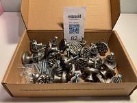 Cardboard box containing 26 pewter round metal drawer pulls with screws