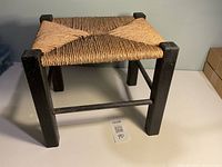 Perspective view of stool showing woven seat pattern and wood frame