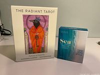 Front view of both boxed card sets