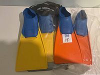 Two pairs of FINIS long floating swim fins, blue/yellow and blue/orange