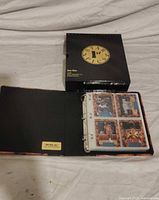 Closed black Star Pics binder beside open binder showing plastic sleeves with cards