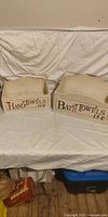 Front view of cream wooden bath and hand towel crates side by side showing printed graphics
