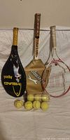 Three rackets with covers, tennis balls, tube