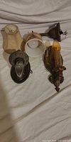 Group shot of all three brass sconces with bulbs and shades