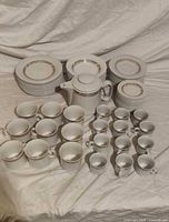 Overall set showing plates, teacups, espresso cups and teapot on cloth background