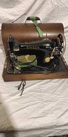 Singer sewing machine on wooden base with open bentwood case