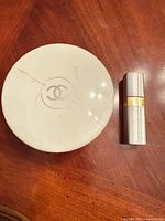Round white Chanel powder container and silver travel atomizer