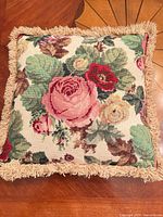 Front view of floral needlepoint pillow with fringe