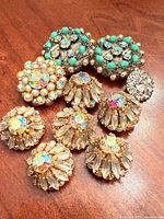 Group shot of all 10 embellished buttons on wooden surface