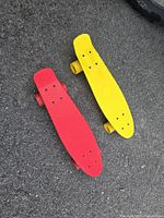 Top view showing red and yellow skateboards on pavement