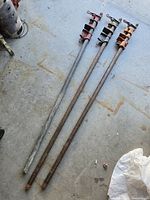 Three full-length pipe clamps laid on floor