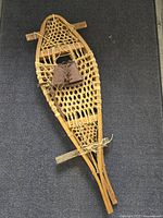 Full view of one snowshoe showing frame, webbing, binding