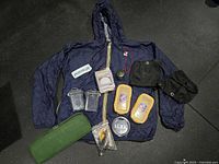 Full lot layout showing jacket, gaiters, containers, cases, compasses, light, pouch, patch