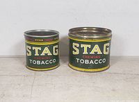Front view of both Stag Chewing Tobacco tins showing size difference and graphics