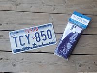 License plate and packaged flag on wood surface