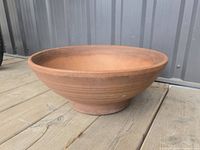 Side view of terracotta bowl planter on deck