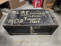 Top view of wooden crate with hand-painted address and metal corners