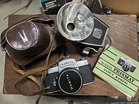 Top view of camera, lens, case, flash and manual displayed together