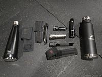 Overall layout showing two water bottles, four flashlights, three holsters