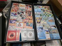 Wide view of two trays filled with assorted Pokémon cards