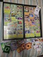 Two trays filled with sorted Pokémon cards plus loose cards below