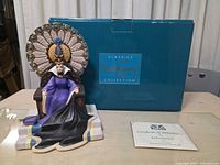 Front view of figurine, box, certificate