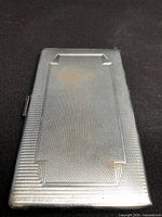 Front view showing engine-turned pattern and stepped border