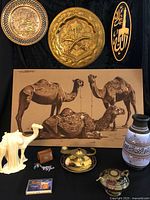 Group shot showing camel painting, three plaques, vase, camel figurine, lamps, plate, trinket box and cassette