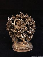 Front view of brass Vajravarahi figurine within flaming halo