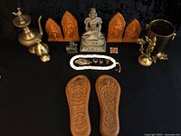 Full lot overview showing brass vessels, deity idol, terracotta plaques, mala and sandals