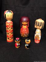 Group view of all five kokeshi dolls standing together