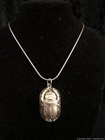 Front view of silver-tone scarab beetle pendant on display chain
