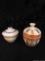 Both lidded bowls side by side, showing overall form and decoration