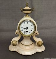 Front view of alabaster mantel clock with urn finial and ormolu mounts