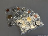 Multiple sealed Canadian coin sets overlapped