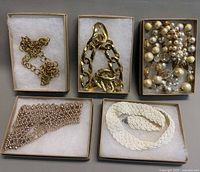 Group shot of all five necklaces in individual boxes