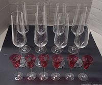 Front view of all 17 champagne flutes and 6 red stemmed shot glasses