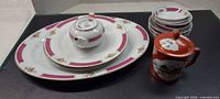 Group view of platter, plates, bowls, teapot and sugar jar
