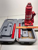 Bottle jack inside open plastic case with handle pieces