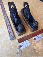 Top view of both Hunt Mfg transitional planes No.8 and No.9 on table with rulers and tags visible