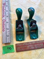 Top view of two green Kunz No. 100 squirrel tail planes beside ruler for scale
