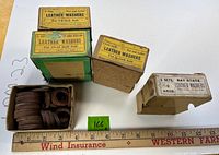 Four open boxes of leather washers with labels visible